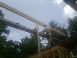 Carpenter setting a ridge beam over a new addition frame — Ice Dam Removal by Roofing Brothers in Nashotah