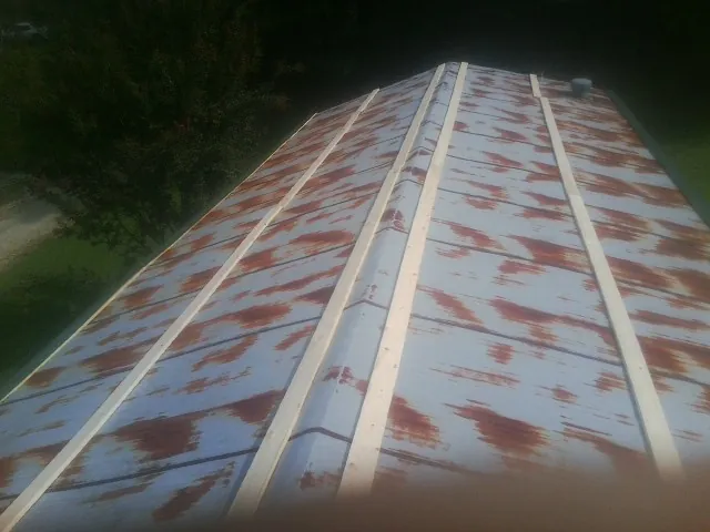 Rusted metal roof panels with new wood purlins before replacement — Storm Damage Roof Repair in Nashotah by Roofing Brothers