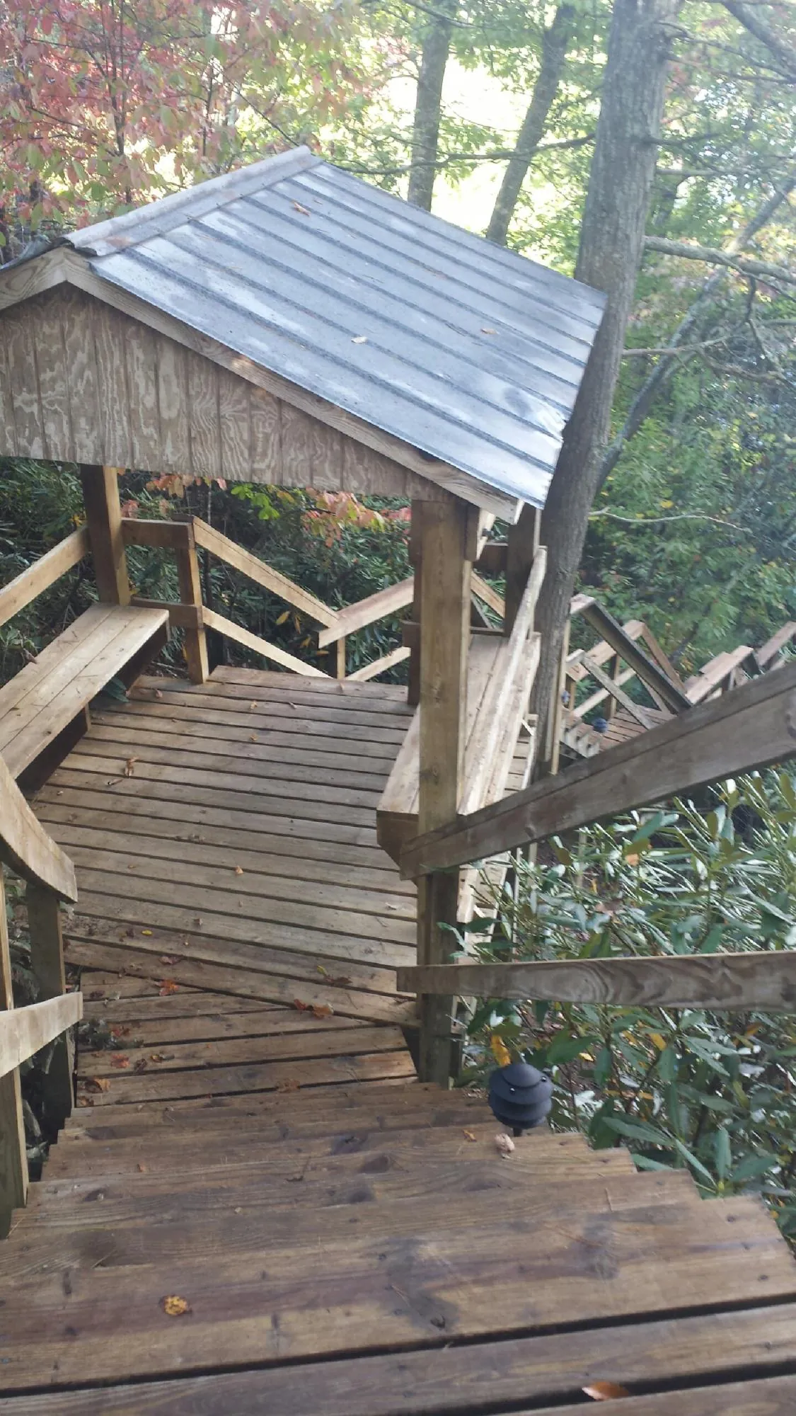 Metal roofed shelter over wooden steps on a wooded walkway — Skylight Repair & Installation work by our crew in Nashotah