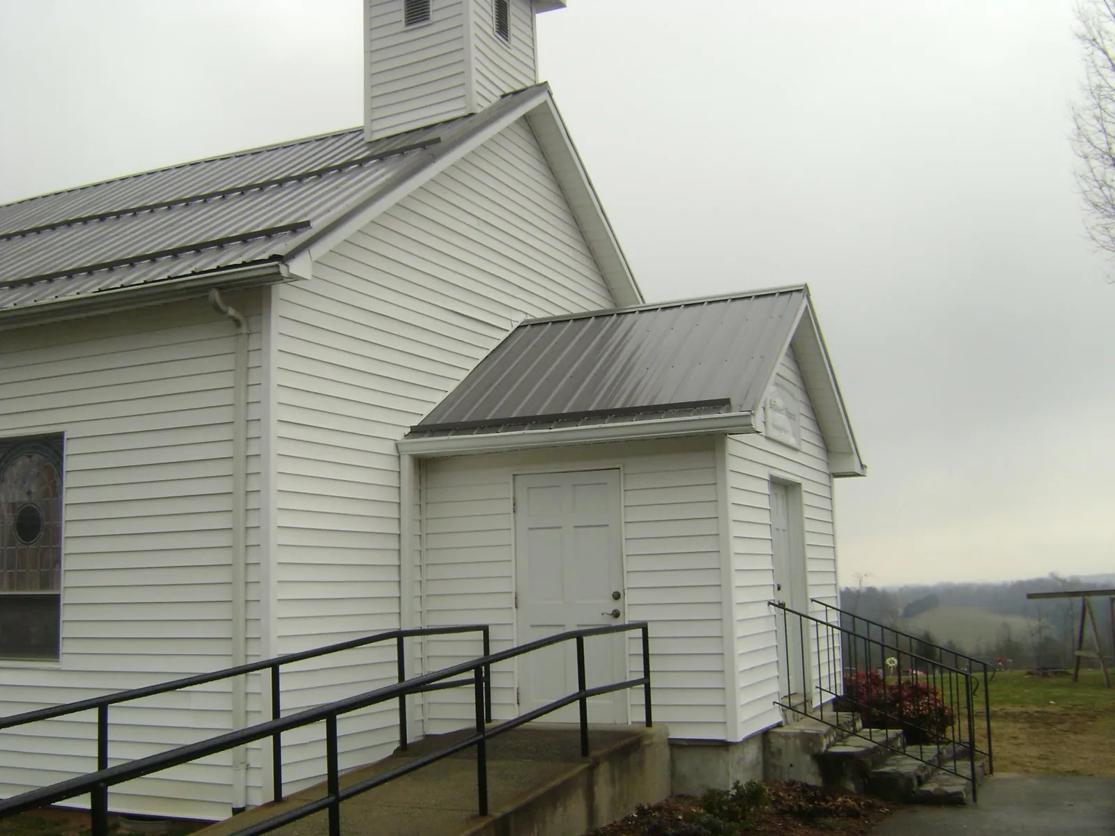 Gray metal roof on a white clapboard church with a steeple in Nashotah